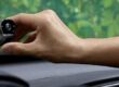 Hand monterar en liten bilkamera vid vindrutans övre kant