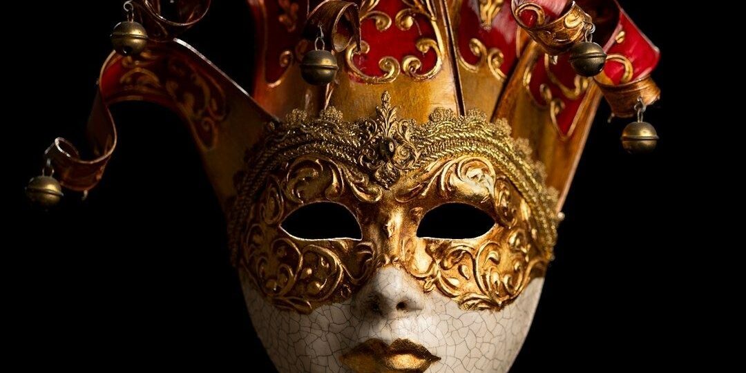 Utsmyckad röd och guldfärgad maskeradmask mot svart bakgrund