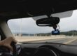 Bil kör på en bro med en dashcam monterad bakom backspegeln