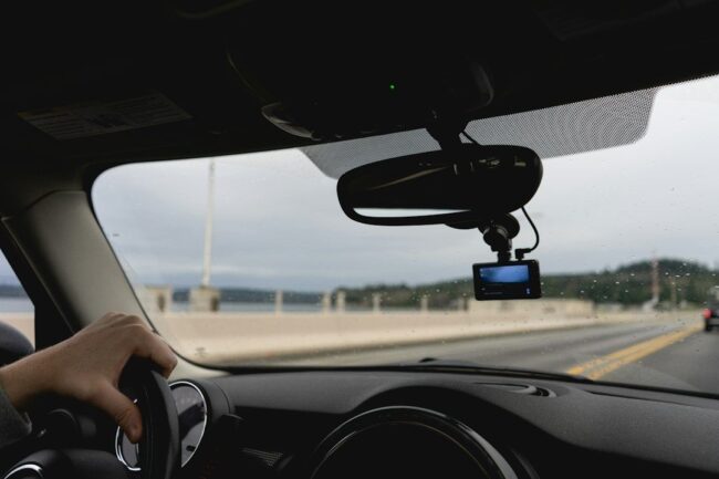 selected-01-micro-sd-card-dashcam-optimized Bil kör på en bro med en dashcam monterad bakom backspegeln